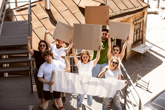 Grupo diverso de personas protestando con carteles en blanco. Protesta contra los derechos humanos, abuso de libertad, problemas sociales.