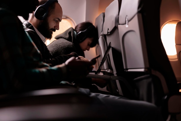 Grupo diverso de personas que viajan en vuelos comerciales con servicio de vías aéreas internacionales. Volar en avión durante la puesta de sol para llegar al destino de la aerolínea, sintiéndose asustado por el despegue y el vuelo.