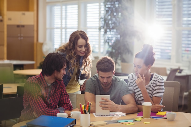 Grupo de ejecutivos de negocios que discuten sobre la tableta digital en t