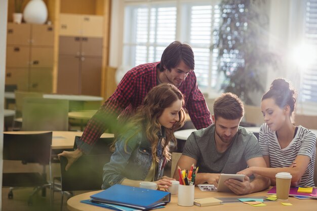 Grupo de ejecutivos de negocios que discuten sobre la tableta digital en t