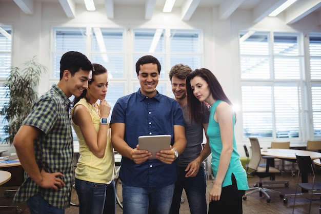 Grupo de ejecutivos de negocios que discuten sobre la tableta digital