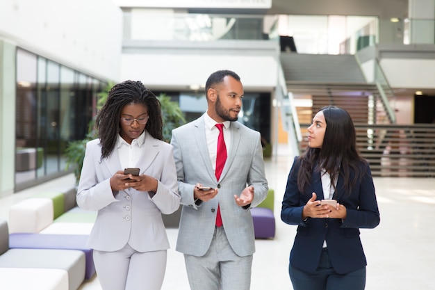 Grupo empresarial con celulares discutiendo proyecto