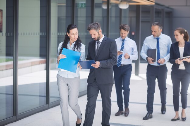 Grupo de empresarios caminando fuera del edificio de oficinas