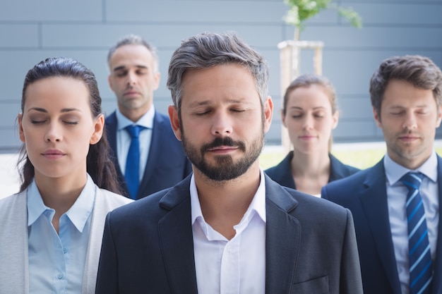 Grupo de empresarios con los ojos cerrados