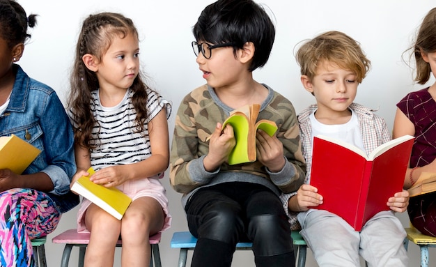 Grupo de estudiantes está sentado y leyendo un libro.