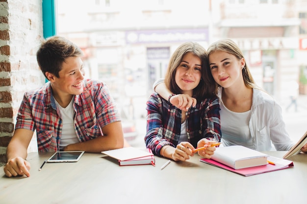 Grupo de estudiantes con libros en la mesa