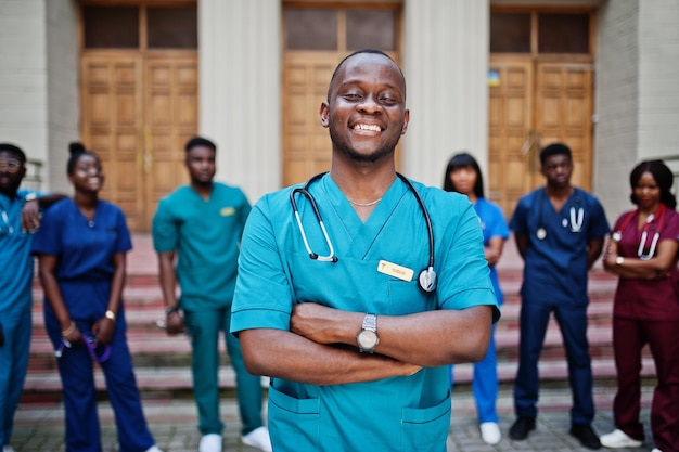 Grupo de estudiantes de medicina africanos posaron al aire libre contra la puerta de la universidad