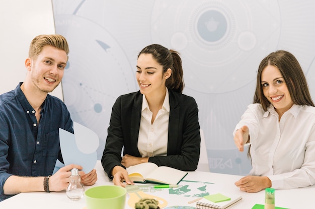 Grupo de felices empresarios hombres y mujeres sentados en la oficina