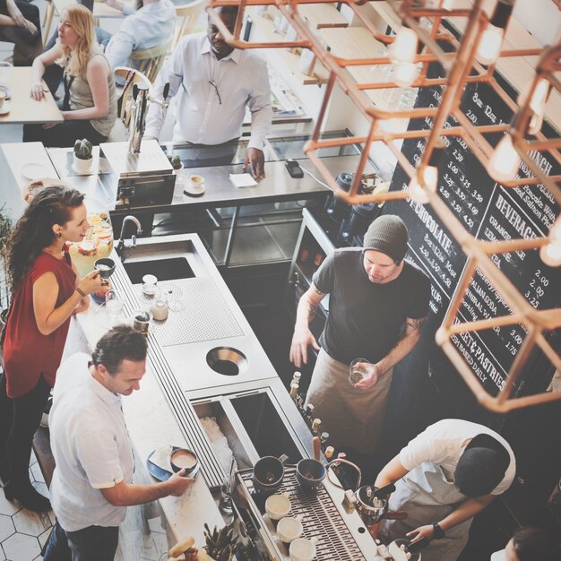 Grupo de gente diversa que ordena la cafetería del café