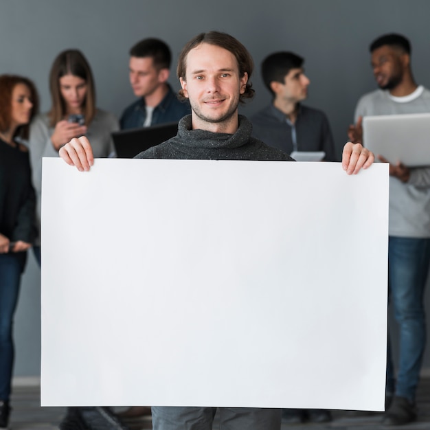 Grupo de gente sujetando plantilla de papel en blanco