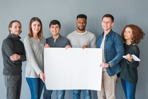 Grupo de gente sujetando plantilla de papel en blanco