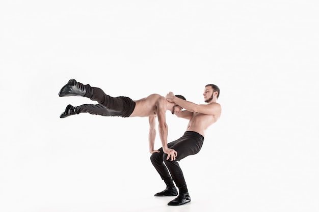 El grupo de hombres caucásicos acrobáticos gimnásticos en pose de equilibrio