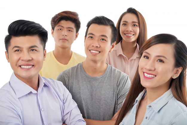 Grupo de hombres y mujeres asiáticos sonrientes de pie juntos y mirando hacia arriba