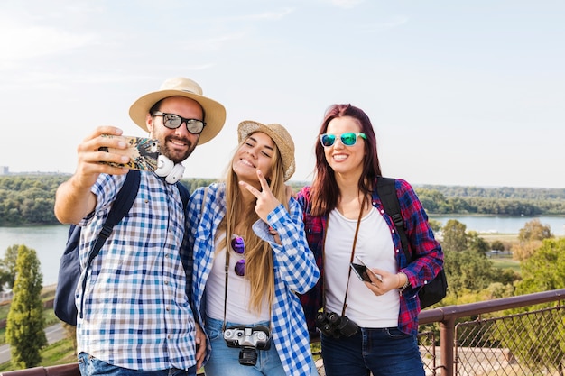 Grupo de hombres y mujeres excursionistas tomando selfie en teléfono móvil