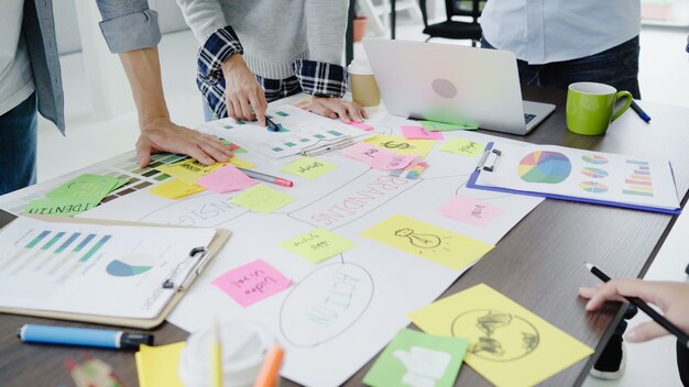 Grupo de hombres de negocios ocasional vestidos que discuten ideas en la oficina.