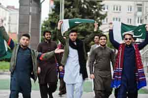 Foto gratuita grupo de hombres paquistaníes vestidos con ropa tradicional salwar kameez o kurta con banderas de pakistán