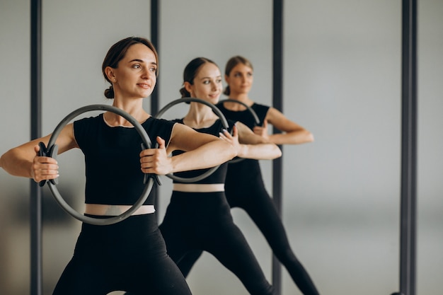 Grupo de instructores de pilates haciendo ejercicio en reformadores