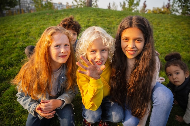 Grupo interracial de niños, niñas y niños jugando juntos en el parque en verano