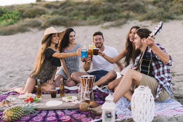 Grupo joven de amigos haciendo una fiesta de playa