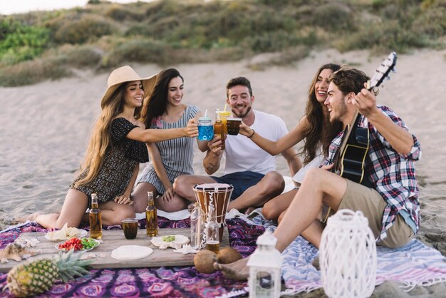 Grupo joven de amigos haciendo una fiesta de playa