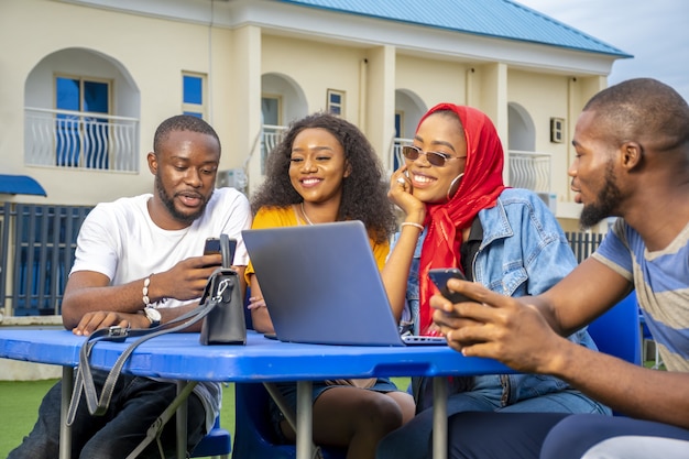 Grupo de jóvenes africanos colgando en un café al aire libre