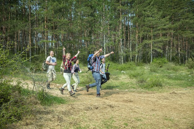 Grupo de jóvenes amigos felices divirtiéndose en la naturaleza en un día soleado de verano