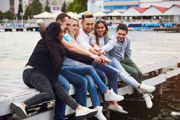 Grupo de jóvenes amigos felices en el muelle, el placer de jugar crea vida emocional.