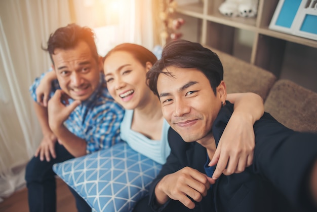 Grupo de jóvenes amigos haciendo selfie con teléfono inteligente en partido.