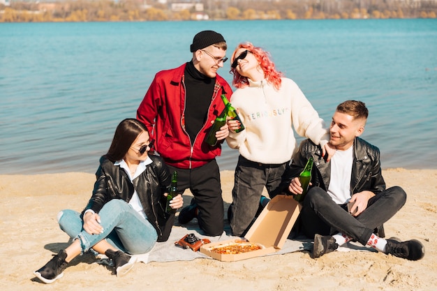 Grupo de jóvenes amigos en picnic a la orilla del mar