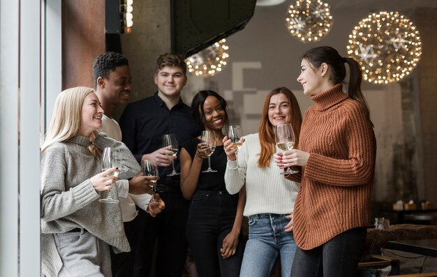 Grupo de jóvenes disfrutando juntos de copas de vino