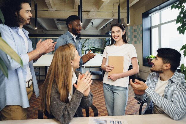 Grupo de jóvenes empresarios aplauden a su colega después de la presentación