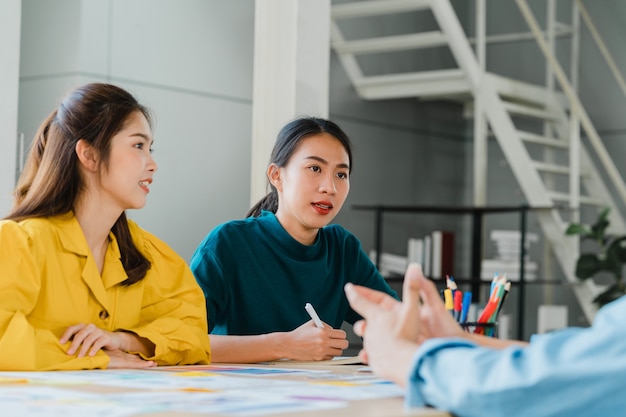 Foto gratuita grupo de jóvenes estudiantes universitarios en ropa casual elegante en el campus. reunión de intercambio de ideas de amigos hablando y discutiendo ideas de trabajo nuevo proyecto de diseño en la oficina moderna. trabajo en equipo de compañeros de trabajo, concepto de inicio.