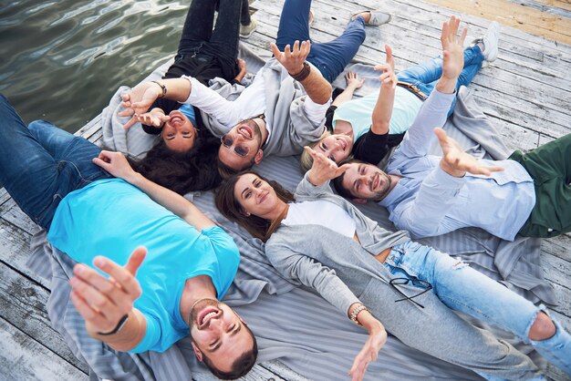 Un grupo de jóvenes y exitosos amigos de vacaciones disfrutando de un juego en el lago. Emociones positivas.