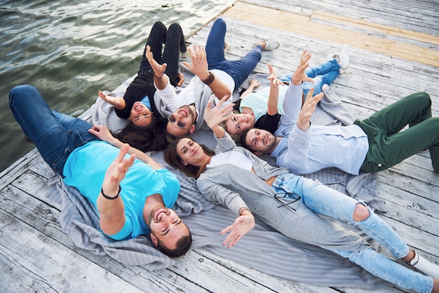 Un grupo de jóvenes y exitosos amigos de vacaciones disfrutando de un juego en el lago. Emociones positivas.