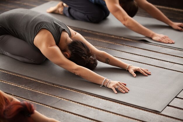 Grupo de jóvenes en pose balasana.