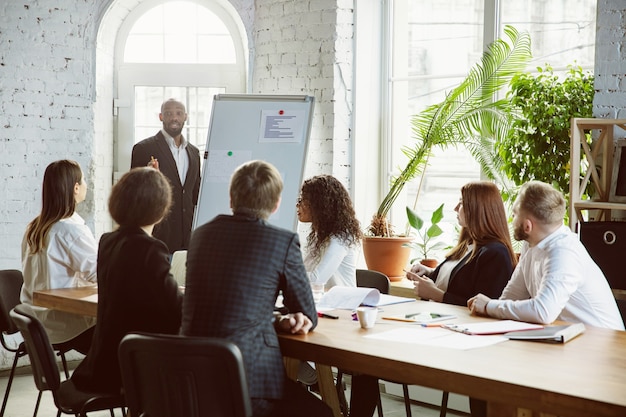 Grupo de jóvenes profesionales de negocios que tienen una reunión, oficina creativa