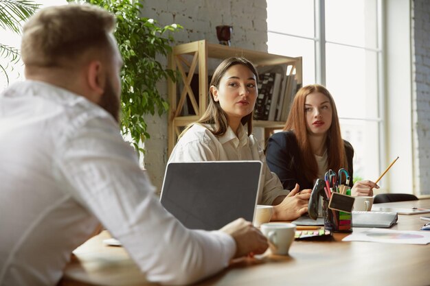 Grupo de jóvenes profesionales de negocios que tienen una reunión, oficina creativa