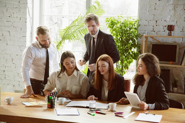 Grupo de jóvenes profesionales de negocios que tienen una reunión, oficina creativa