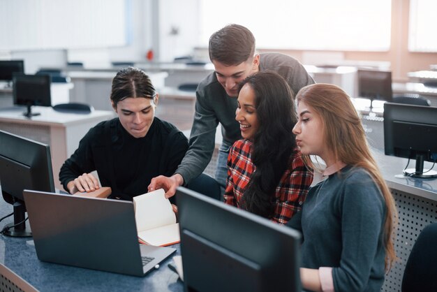 Grupo de jóvenes en ropa casual que trabajan en la oficina moderna