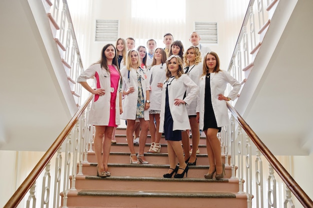 Grupo de médicos jóvenes en batas blancas posando en el hospital