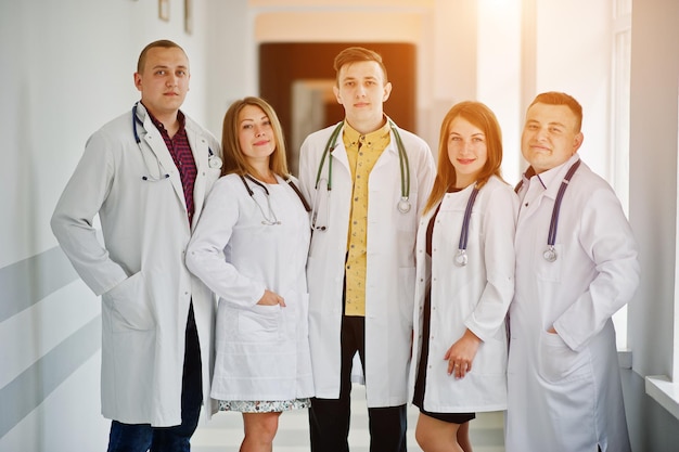 Grupo de médicos jóvenes en batas blancas posando en el hospital