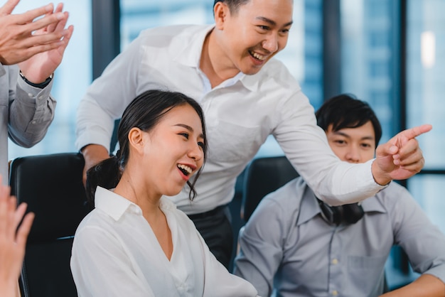 Grupo milenario de jóvenes empresarios Asia empresario y empresaria celebran dando cinco después de tratar de sentirse feliz y firmar un contrato o acuerdo en la sala de reuniones en la pequeña oficina moderna.