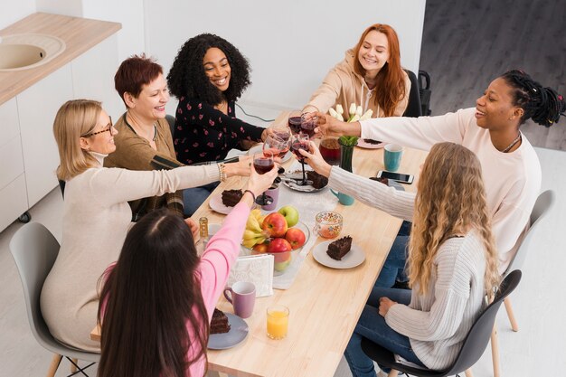 Grupo de mujeres de alto ángulo haciendo un brindis