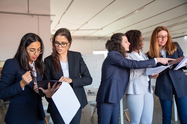 Grupo de mujeres concentradas estudiando nuevo proyecto