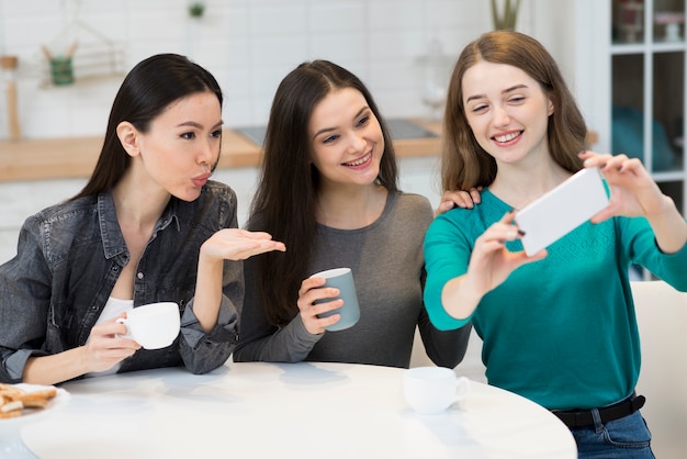 Foto gratuita grupo de mujeres jóvenes tomando una selfie juntos