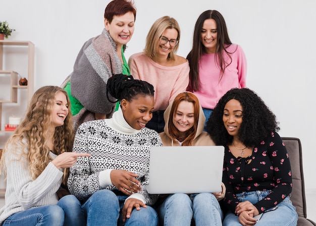 Foto gratuita grupo de mujeres mirando a través de una computadora portátil