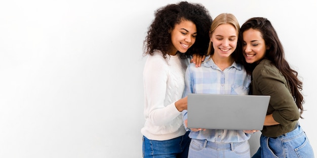 Grupo de mujeres de negocios navegando por una computadora portátil