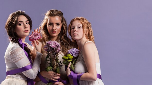 Grupo de mujeres posando con flores y espacio de copia