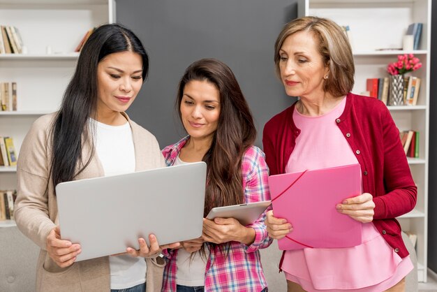 Grupo de mujeres que buscan en la computadora portátil