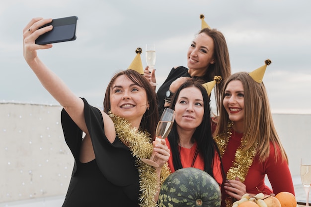 Grupo de mujeres sonrientes tomando un selfie grupal